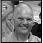 Smiling bald man in a casual setting.