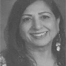 A smiling woman with earrings and long hair in a black-and-white photo.